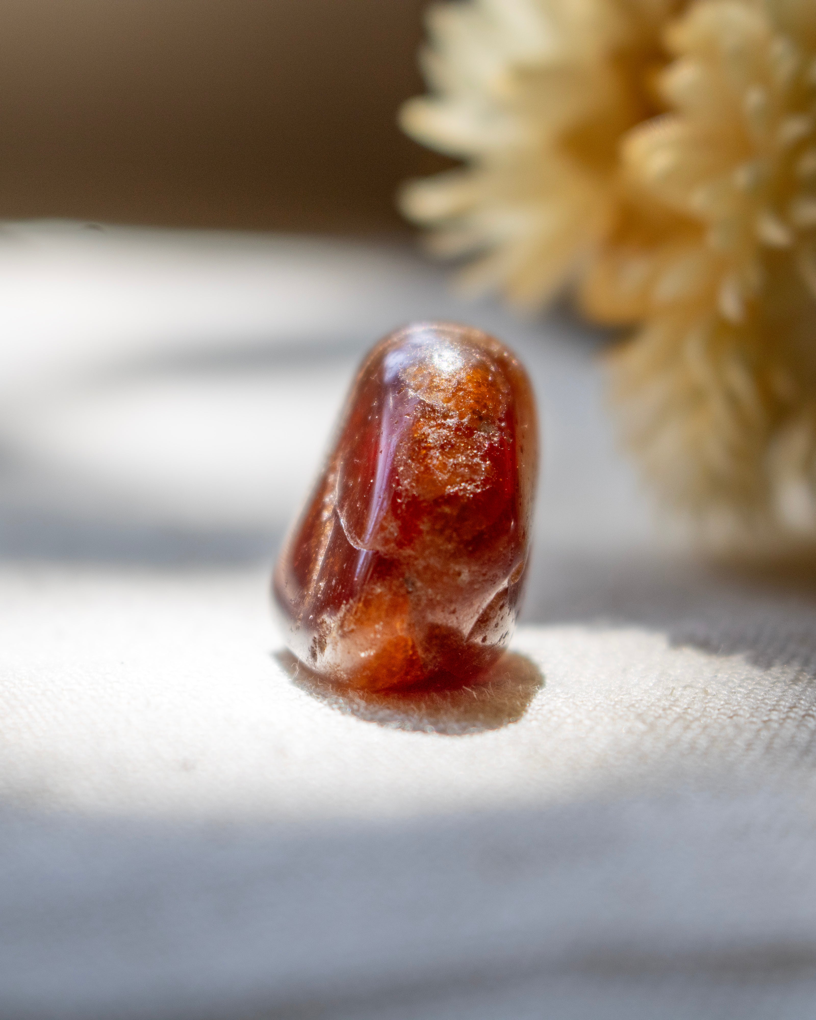 Close-up of a red stone on a textured surface with a blurred background