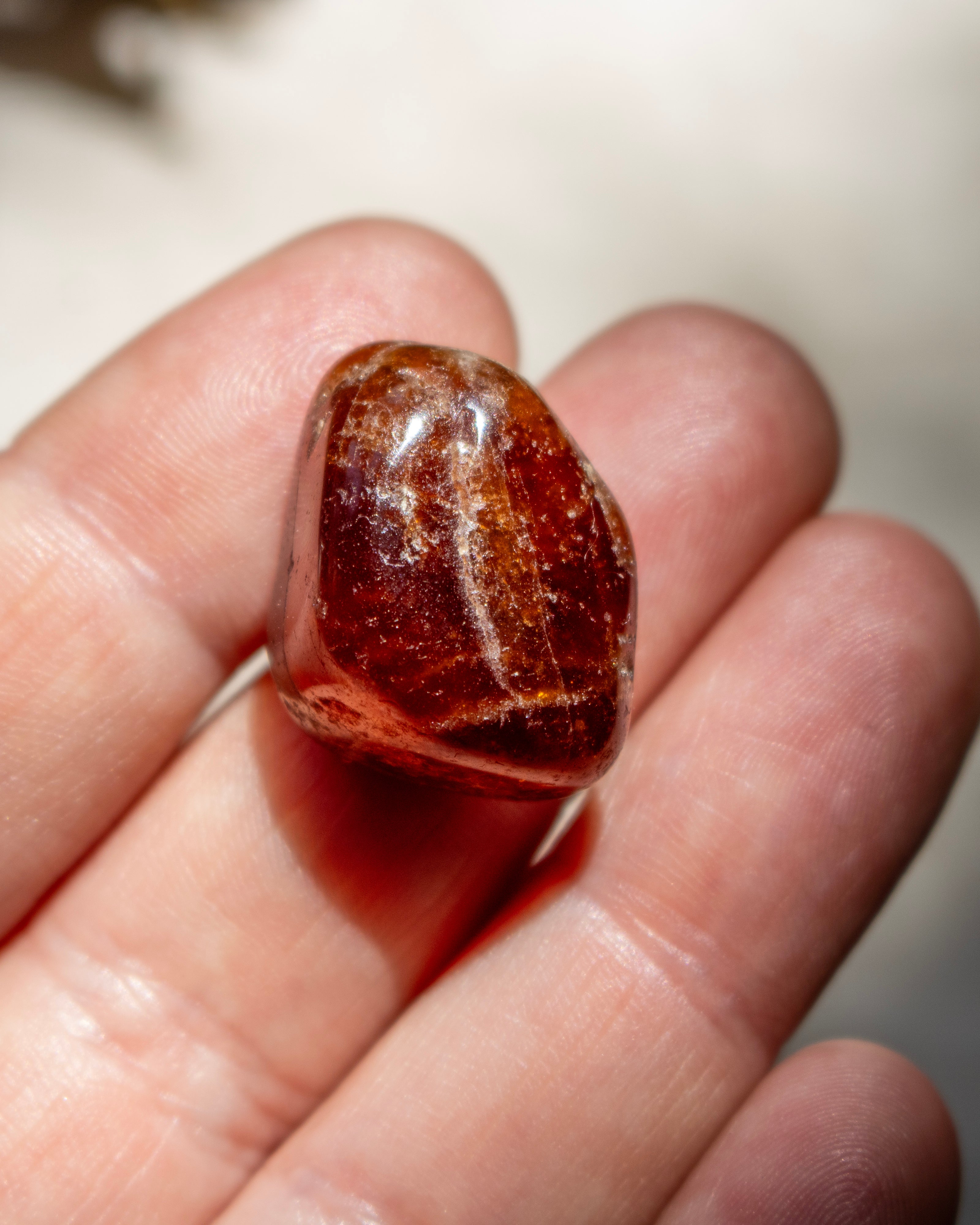 Brown stone held between fingers against a blurred background