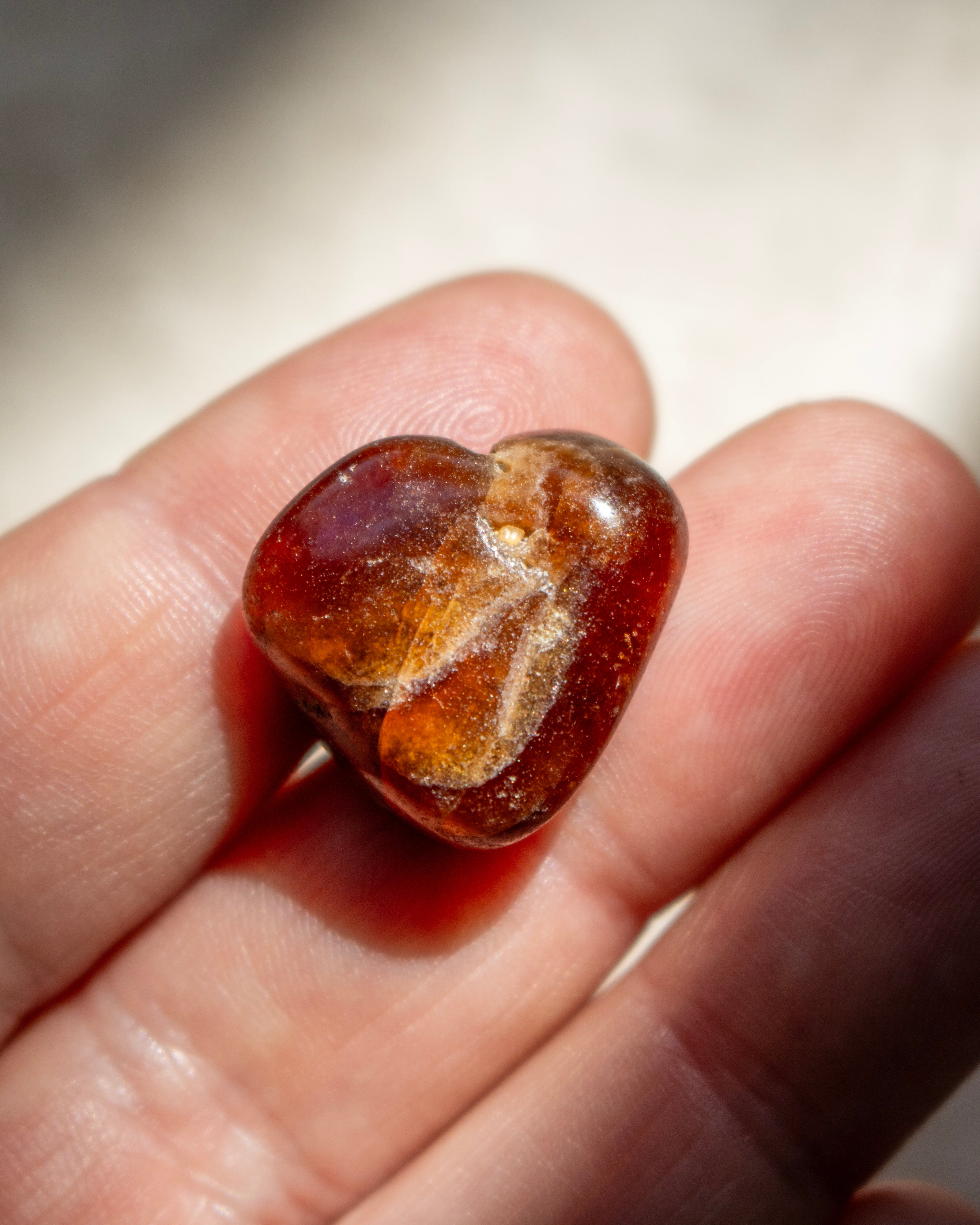 Brown stone held in a hand with a blurred background